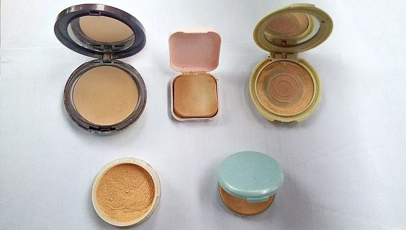 Ilustrasi generik bedak padat dan tabur dalam kemasan compact — bukan foto produk Viva, konfirmasi varian via WA